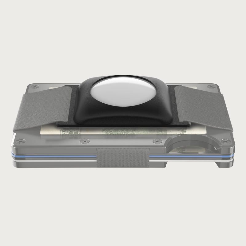 Black AirTag cash strap holding a bill on a clear metal wallet, front angle view.