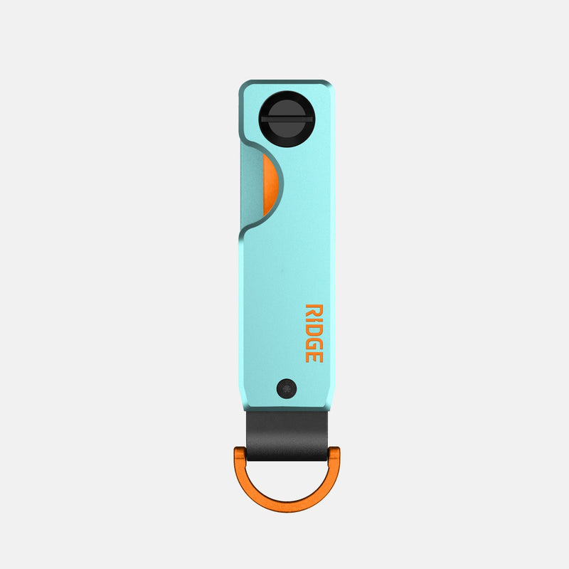 Ridge KeyCase in mint green with orange accents, front view showing locking dial and black strap with orange clip.