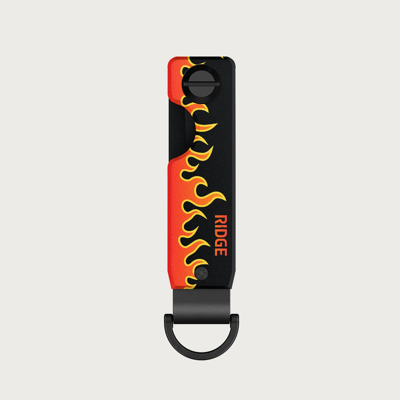 Ridge KeyCase in black with orange and yellow flame graphic, shown front-on with carabiner loop attached.