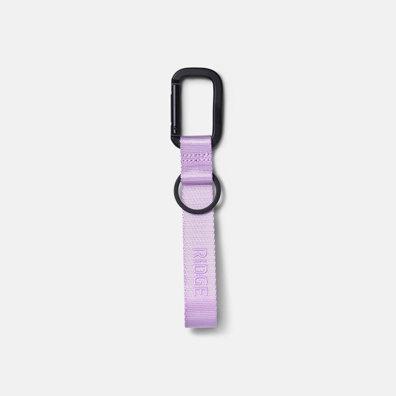 Ridge Keychain in lavender webbing with black carabiner clip and ring, embossed logo, on plain background.